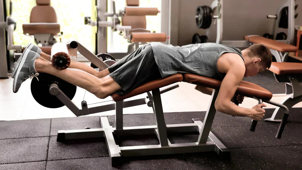 Homme en train de faire du leg curl a la salle de sport