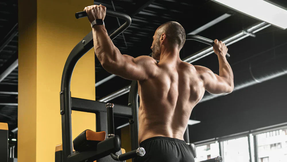 Homme musclé en train de faire une série de traction dans une salle de gym