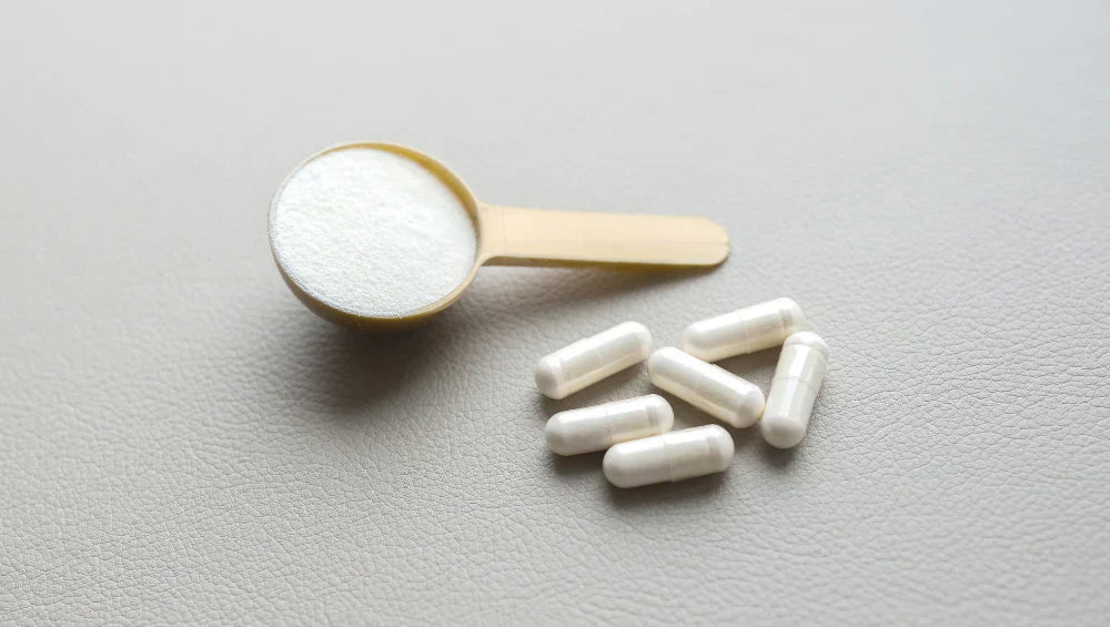 Plusieurs pilules de vitamine C avec une cuillère de collagène