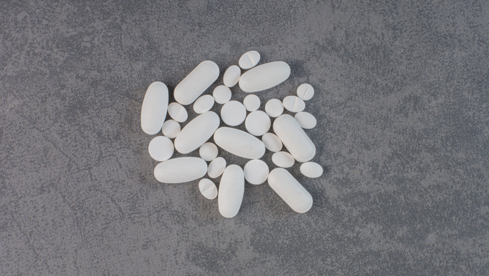 Plusieurs pilule blanche sur un fond gris