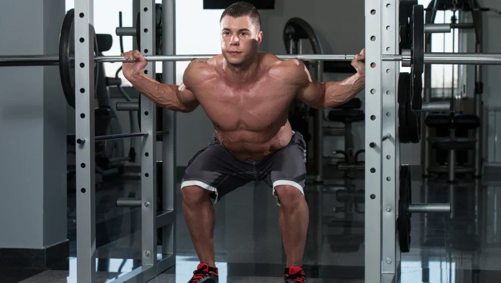 Homme musclé en train de faire un squat dans une salle de sport