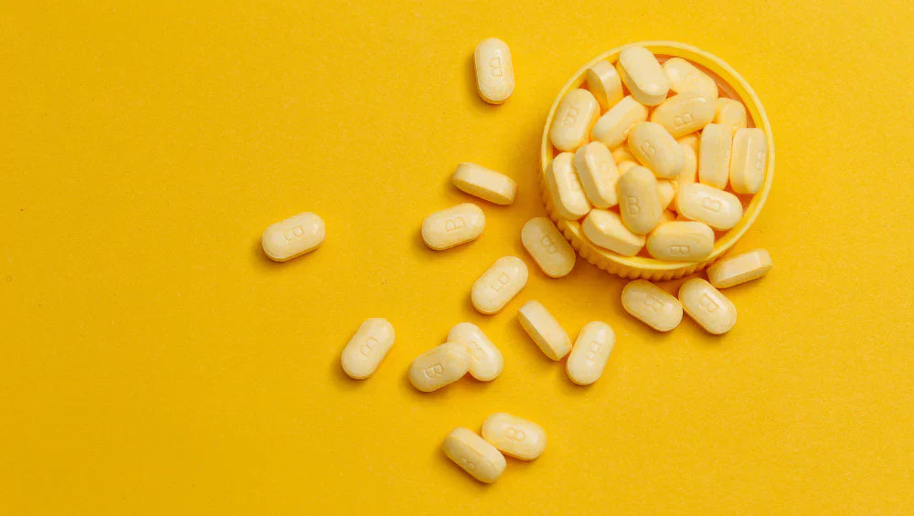 Plusieurs comprimé de vitamine B de couleur jaune sur un fond jaune